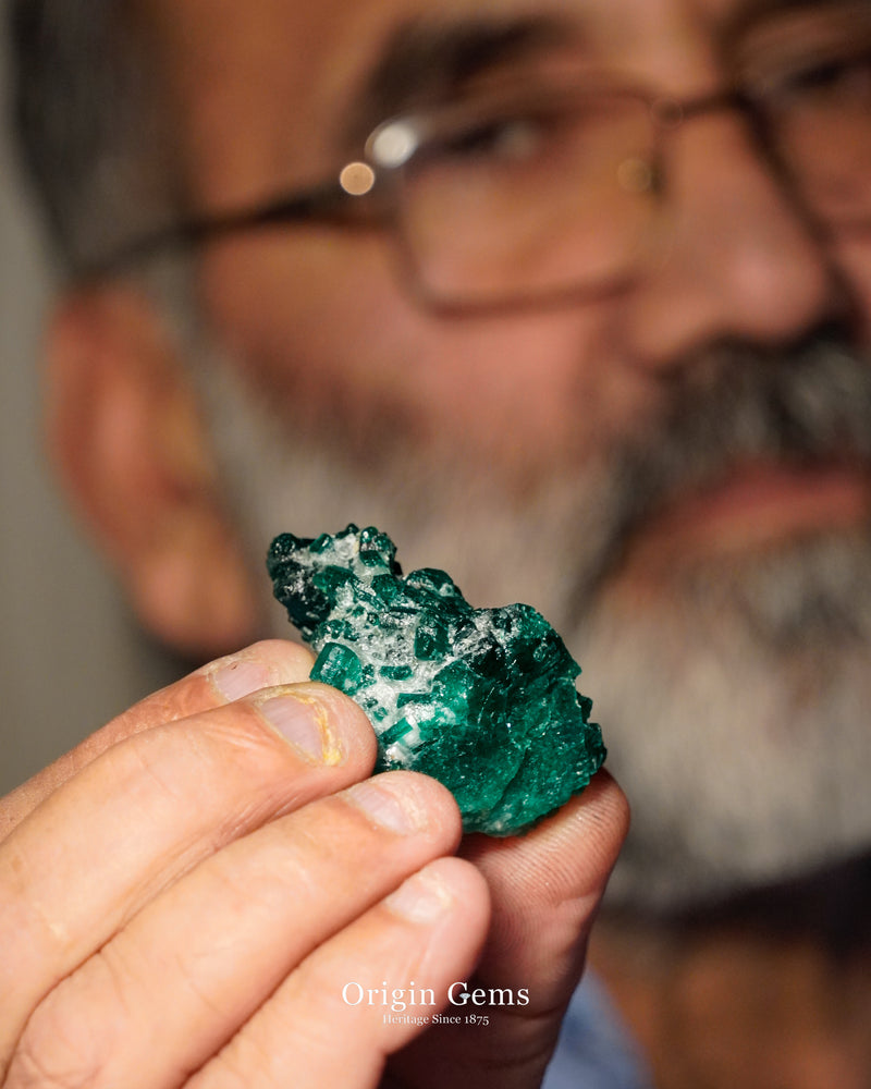Old local dealer and miner in Swat gemstone Emerald centre outside the Mingora mines holding a natural Emerald rough crystal.